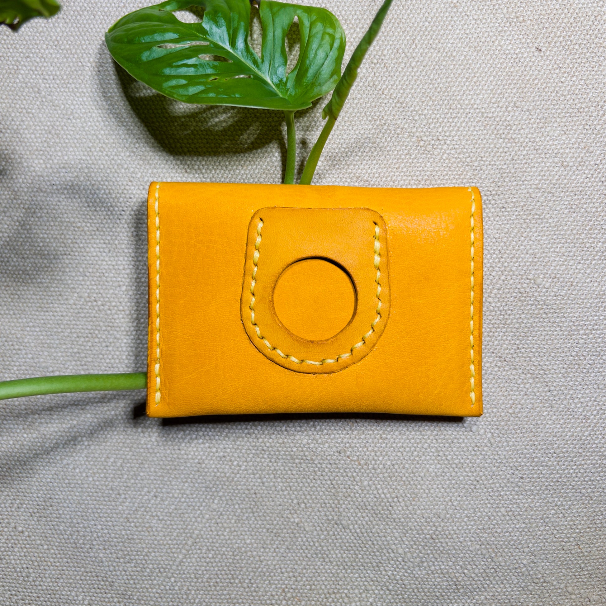 Yellow leather wallet with circular design on a gray background
